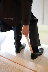靴ベラを使う人の画像