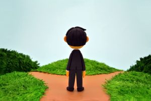 分岐点に立つ人の画像